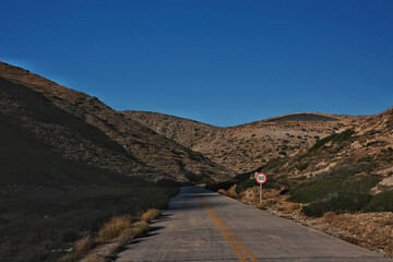 View of an empty road on the island of Ios Greece and a speed limit sign