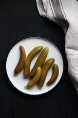 Cucumber pickles in a plate on a black background