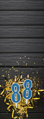 Number 88 blue celebration candle and gold confetti on dark wooden background. 88th birthday card. Anniversary and birthday concept. Vertical banner.