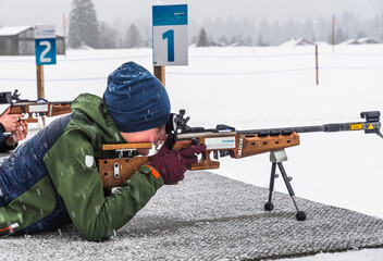 Boy doing shooting practice with a laser rifle for biathlon training in winter