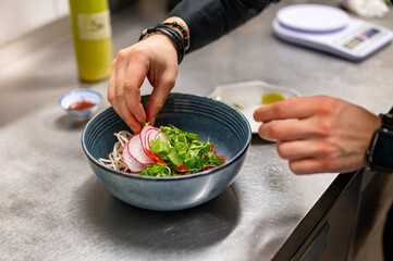 Close up of chef's hands cooking asian pho bo soup on restaurant kitchen