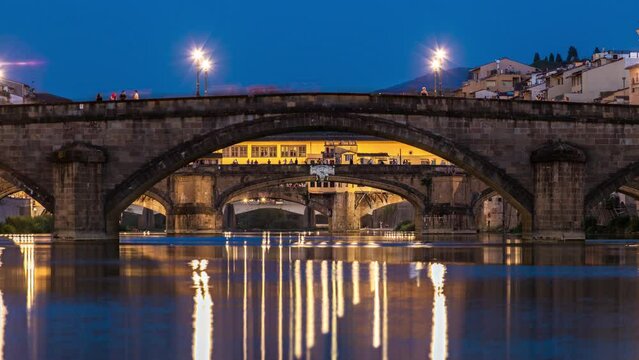 Twilight scene of Ponte Alla Carraia and Santa Trinita (Holy Trinity Bridge) day to night transition timelapse over River Arno with reflections on water after sunset. Florence, Tuscany, Italy
