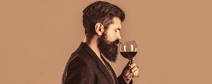 Beard man, bearded, sommelier tasting red wine. Man with a glass of red wine in his hands. Sommelier, degustator with glass of wine, winery, male winemaker