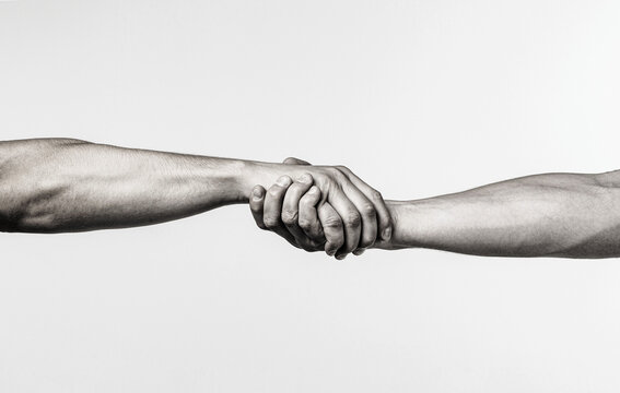 Friendly handshake, friends greeting, teamwork, friendship. Close-up. Rescue, helping gesture or hands. Strong hold.