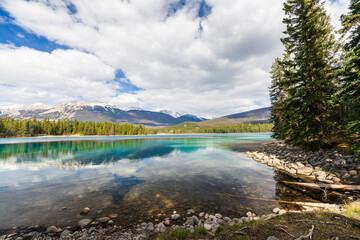 Lake Annette lake shore beach, Pyramid mountain reflection on the lake. Jasper National Park stunning nature scenery in summer time. Landscape of Canadian Rockies, Alberta, Canada.