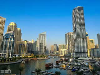 Fototapeta premium Dubai Marina, harbour, cruise boat and canal promenade view at sunset, in Dubai, United Arab Emirates