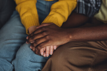 Mixed ethnicity couple, international family, African American man and caucasian woman holding hands. Love, trust, support of people of different skin colour, race, culture. Session at psycologist