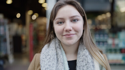 Young blonde woman smiling confident standing at street