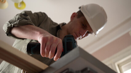 male craftsman working with wood using a screwdriver.