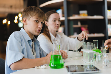 Caucasian kids and caucasian teacher learning science with chemical test tube 