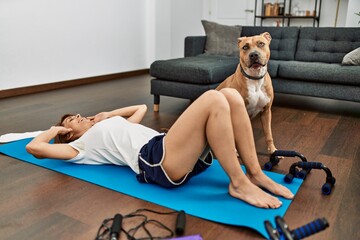 Naklejka premium Young caucasian woman smiling confident training abs exercise at home