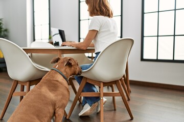 Young caucasian woman using laptop sitting on table at home