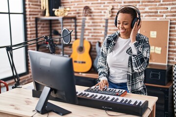 Fototapeta na wymiar African american woman musician having dj session at music studio