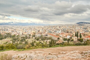 Fototapeta na wymiar View on Athens from Pantheon on winter during cloudy cold day with snow on the mountain in background
