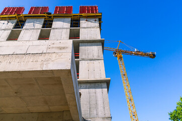 A tower construction crane. Boom rotary crane with boom. Construction of apartment buildings in the city. Construction of high-rise buildings.