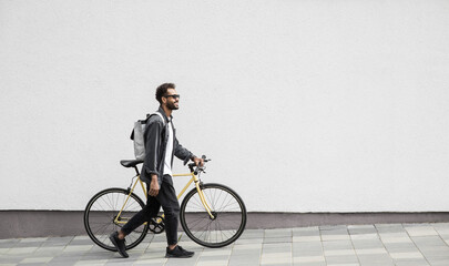 Young handsome man with bike over white wall background in a city, Smiling student man with bicycle outdoor, Modern healthy lifestyle, travel, casual business concept