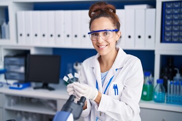 Young woman scientist holding samples working at laboratory