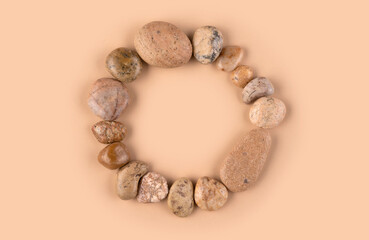 Background in pink. Stones arranged in a circle in the middle.
