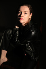 portrait of a woman in leather black clothes in the dark