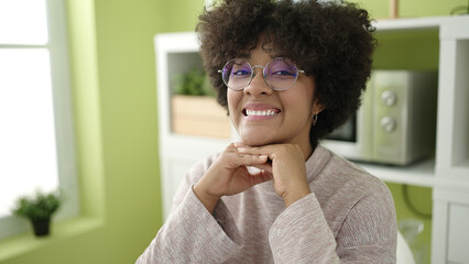 Fototapeta na wymiar Young african american woman smiling confident sitting on table at home