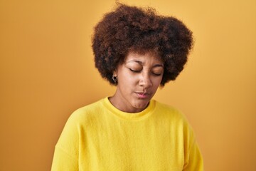 Fototapeta na wymiar Young african american woman standing over yellow background with hand on stomach because nausea, painful disease feeling unwell. ache concept.