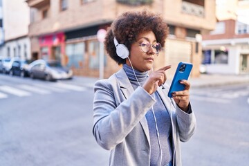 African american woman executive smiling confident listening to music at street