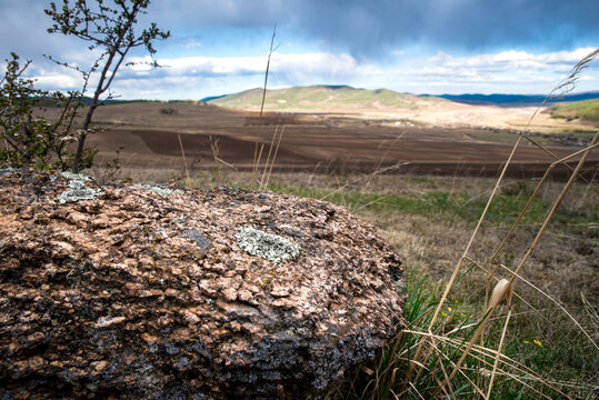 stone lying near the field against the sky and rural landscape