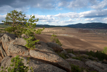 plowed field, arable land, among the rocks, blue sky with clouds, landscape