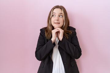 Young caucasian business woman wearing black jacket laughing nervous and excited with hands on chin...