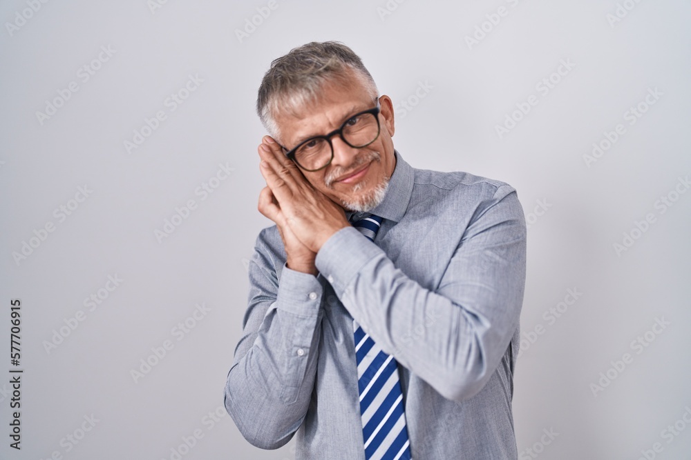 Sticker hispanic business man with grey hair wearing glasses sleeping tired dreaming and posing with hands t