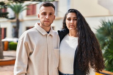 Man and woman couple standing together with relaxed expression at park