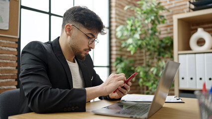 Young arab man business worker using laptop and smartphone at office