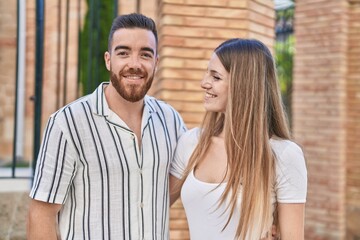 Obraz premium Man and woman couple smiling confident hugging each other at street