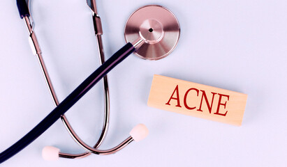 On a blue background, a stethoscope and wooden block with the word ACHE .Medical concept