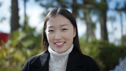 Young chinese woman smiling confident standing at park