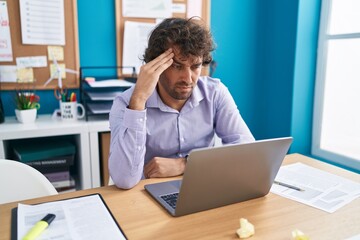 Naklejka premium Young hispanic man business worker stressed using laptop at office