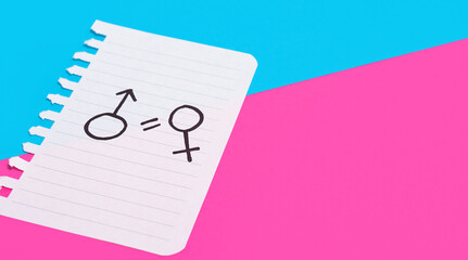 The concept of gender equality. A torn sheet of paper with a female and male symbol drawn on a blue-pink background. Equality of rights between men and women.