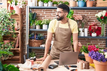 Young arab man florist smiling confident standing at florist