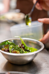 Chef cooking vegetables salad on restaurant kitchen