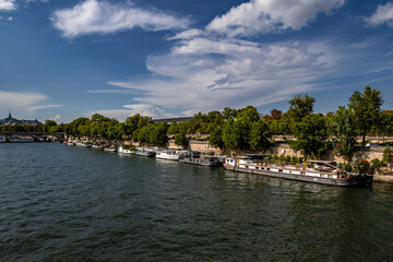 Fototapeta na wymiar River Seine In Paris, France With Promenade And Anchored Houseboats