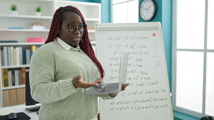 African woman with braided hair teacher teaching maths lesson at university library