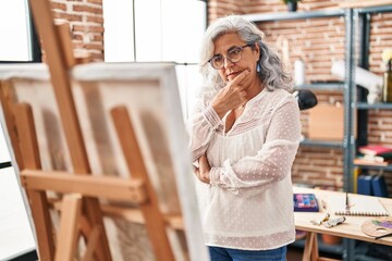 Middle age woman artist looking draw at art studio