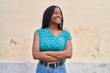 African american woman smiling confident standing with arms crossed gesture at street
