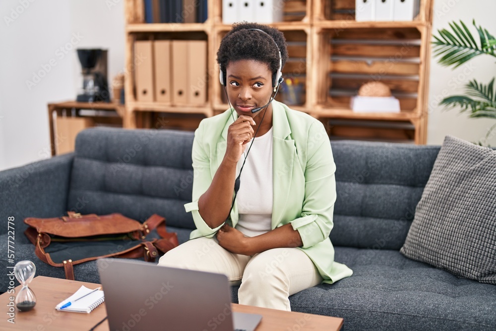 Wall mural African american woman doing online session at consultation office serious face thinking about question with hand on chin, thoughtful about confusing idea