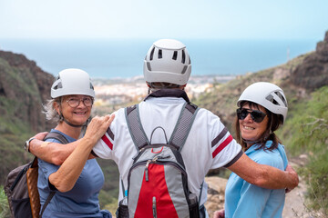 Happy senior friends hikers with backpacks enjoying trekking day on mountain - Smiling climbing tourists enjoying holidays healthy lifestyle - Freedom, success sport concept