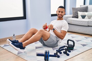 African american man training abs exercise using dumbbell at home
