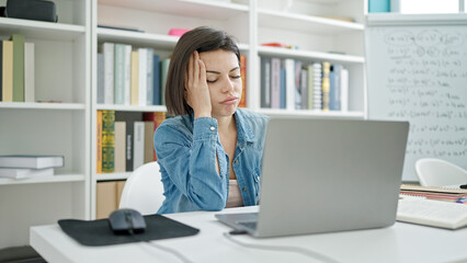 Young caucasian woman student tired studying at university classroom