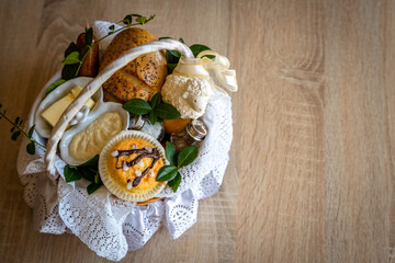 Preparation of a festive Easter Basket. Traditional Blessing of the Easter Food Baskets. Traditions on Holy Saturday. Horseradish, butter, bread, buxus, sausage, muffin, painted eggs and Sugar lamb.