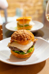 Tasty burger with white crispy ban, beef burger, egg, green lettuce and cheese