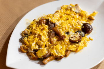 Homemade scrambled eggs with forest mushrooms